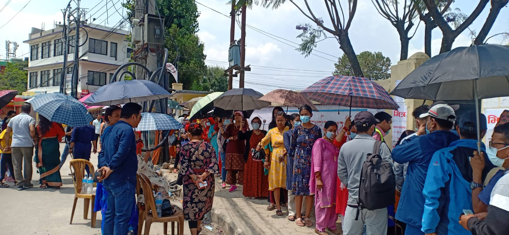 चर्को घाममा छाता ओढेर भोट हाल्न लाइनमा मतदाता (फोटोहरू)